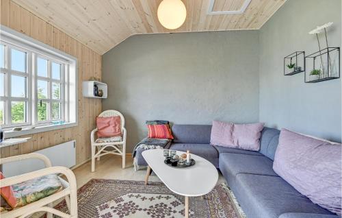 a living room with a blue couch and a table at Three-Bedroom Holiday Home In Knebel in Knebel