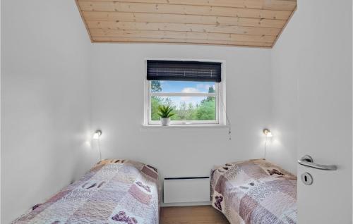 two beds in a room with a window at Holiday Home Marthasvej in Trend