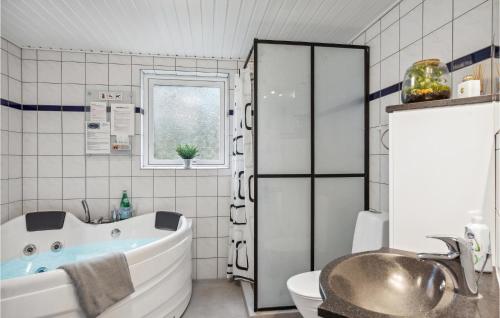 a bathroom with a tub and a toilet and a sink at 4 Bedroom Cozy Home In Brovst in Brovst