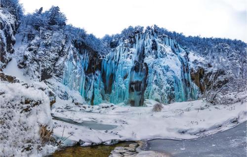 a frozen waterfall in the snow with a river at Two-Bedroom Apartment In Ogulin in Jasenak