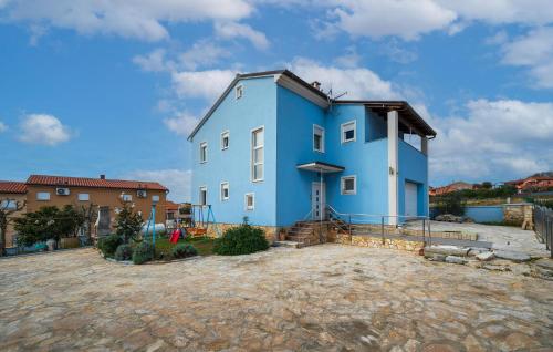 a blue house with a large yard in front of it at Beautiful Apartment In Barbariga in Barbariga
