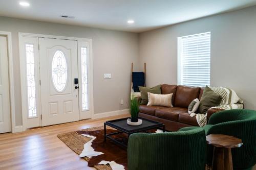 a living room with a brown leather couch and chairs at Family Style Home in South Knoxville in Knoxville