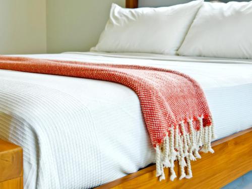 a bed with a red and white blanket on it at Krabi Private Pool Villa 2 by Belcarra Spaces in Ban Khlong Haeng