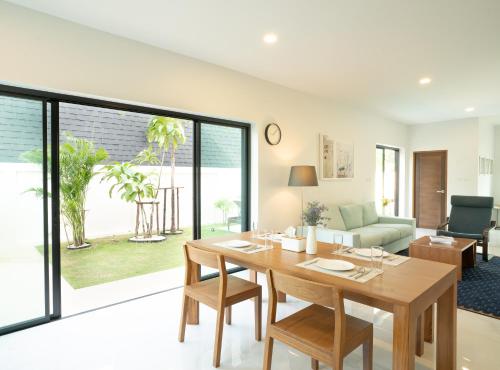 a dining room with a table and a living room at Krabi Private Pool Villa 2 by Belcarra Spaces in Ban Khlong Haeng