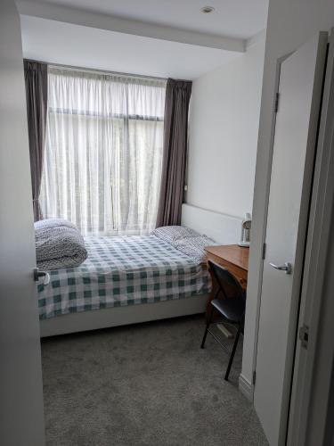 sypialnia z łóżkiem i oknem z biurkiem w obiekcie Newmarket Homestay - Double Room w Auckland