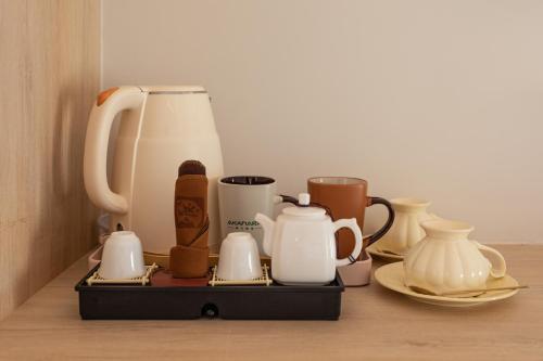 a tray with tea pots and cups on a table at 阿卡那拉橘子海亲子民宿 in Dapeng