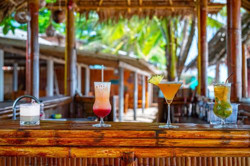 four different cocktails sitting on a wooden bar at Lanta Beachfront Resort in Ko Lanta
