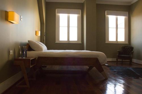 a bedroom with a bed and two windows at El Navegante B&B in Valparaíso