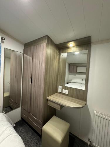 una piccola stanza con un letto e uno specchio di Family Beach Getaway, Pools, Mountains and more a Prestatyn