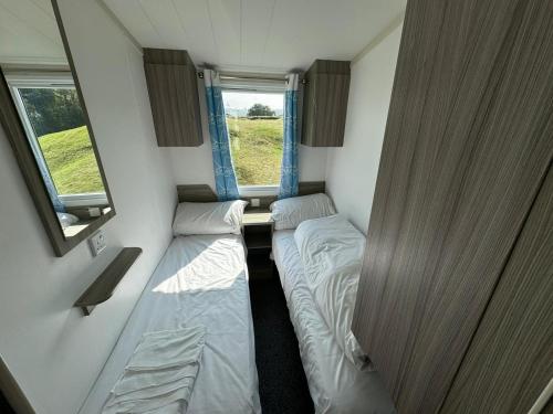 una piccola stanza con due letti e una finestra di Family Beach Getaway, Pools, Mountains and more a Prestatyn