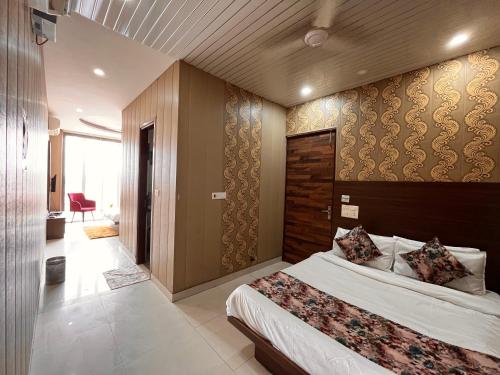 a bedroom with a large bed with a wooden headboard at Hotel The Pearl Grand - Top Rated ! Most Awarded ! Parking ! Lift ! Luxury Rooms ! Best Selling in Chandīgarh