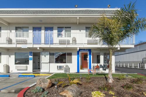 un edificio con una palmera delante de él en Motel 6 Hayward, CA- East Bay en Hayward