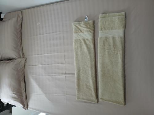 two towels are hanging on a wall at G Lova House -Tetebatu in Tetebatu