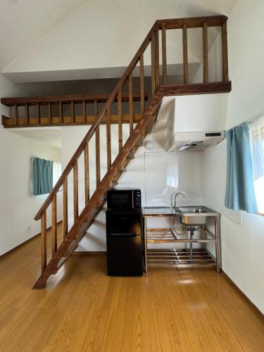 a staircase in a room with a kitchen and a table at コラゾン Resort in Minamidaito