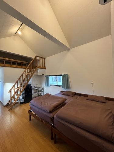 a bedroom with a large bed and a staircase at コラゾン Resort in Minamidaito