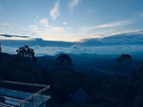 a view of a mountain valley with clouds in the sky at Sky Elanza in Munnar