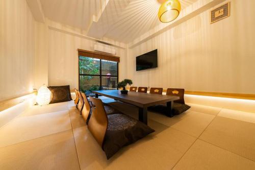 a dining room with a table and chairs at 実れい 疲れを癒す日本庭園と大きなリビング 寝室6 ベッド13 トイレ3 お風呂2台 in Osaka