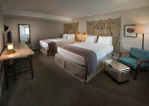 una camera d'albergo con due letti e una sedia di Basecamp Boulder a Boulder