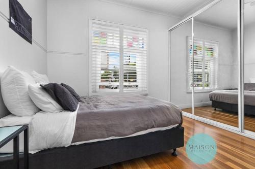 a bedroom with a bed and two windows at 'Urban Chic on Grey' - 3 Bedroom Retreat in Wickham in Wickham