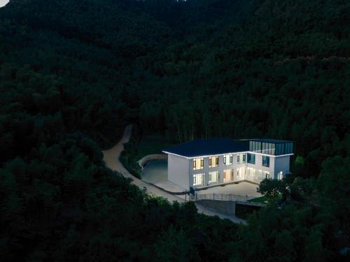 a house in the middle of a forest at night at Tonglu HECHU Laf in Shanyinling