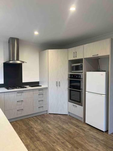 a kitchen with white appliances and a white refrigerator at Hobbiton Countryside Sanctuary in Matamata