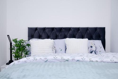 a bed with a black headboard and white pillows at Glory Double Bedroom Manchester in Middleton