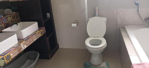 a bathroom with a white toilet and a sink at Blessing in East London