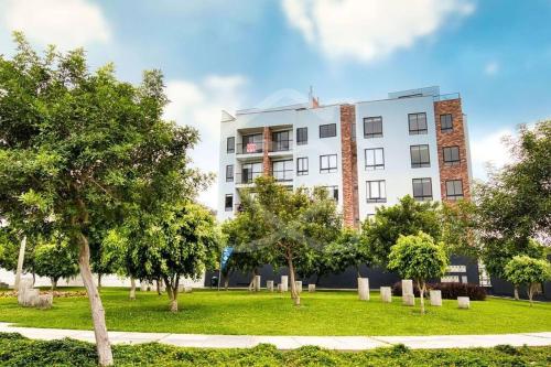 a white building with trees in front of it at Lovely & quiet place, park view & private parking in Lima