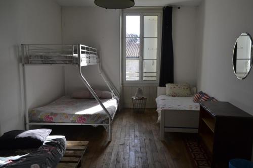 une chambre avec deux lits superposés et une fenêtre dans l'établissement Grande chambre avec 4 lits pour 4 à 5 personnes, à Chef-Boutonne