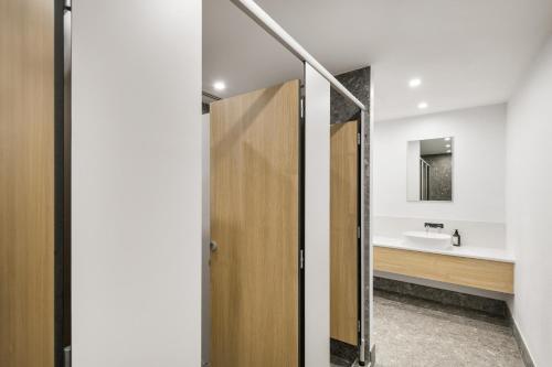 a bathroom with a wooden door and a sink at YHA Brisbane City in Brisbane