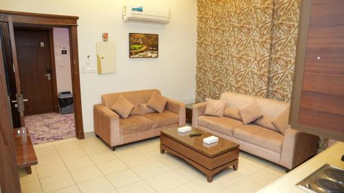 a living room with two couches and a coffee table at هذه ليلتي- اليرموك- طريق الدمام This Lailaty Al Yarmouk-Dammam Road in Riyadh