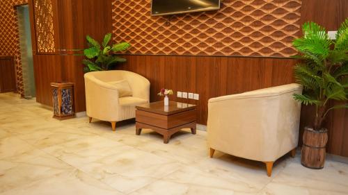 a waiting room with two chairs and a table at هذه ليلتي- اليرموك- طريق الدمام This Lailaty Al Yarmouk-Dammam Road in Riyadh