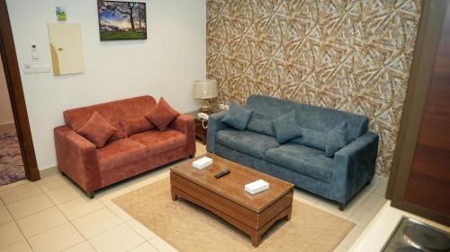 a living room with two couches and a coffee table at هذه ليلتي- اليرموك- طريق الدمام This Lailaty Al Yarmouk-Dammam Road in Riyadh