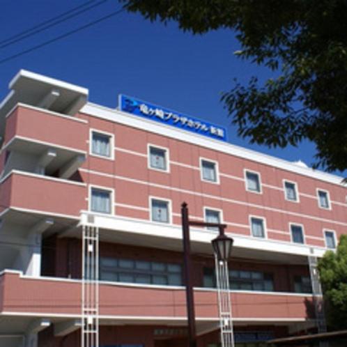 a red building with a sign on top of it at Ryugasaki Plaza Hotel Shinkan in Ryūgasaki