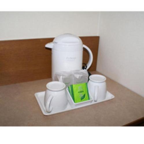 a coffee maker sitting on a plate with three cups at Ryugasaki Plaza Hotel Shinkan in Ryūgasaki
