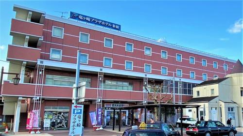 a large red building with cars parked in front of it at Ryugasaki Plaza Hotel Shinkan in Ryūgasaki