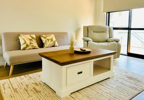 a living room with a couch and a coffee table at Lake Quarter Apartment in Auckland