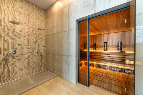 a bathroom with a shower with a wall at Парк Хотел Модър in Devin