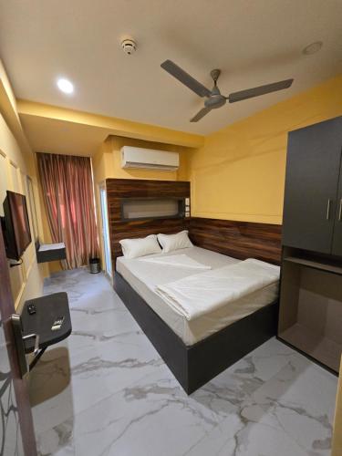 a bedroom with a bed and a ceiling fan at Step Home in Kolkata