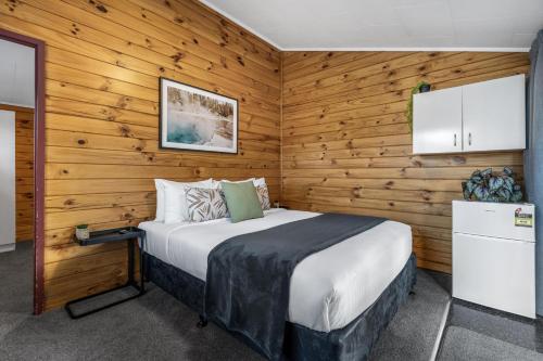 a bedroom with a bed in a wooden wall at Tasman Holiday Parks - Rotorua in Rotorua