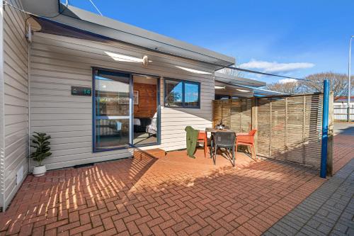 a house with a patio with a table and chairs at Tasman Holiday Parks - Rotorua in Rotorua