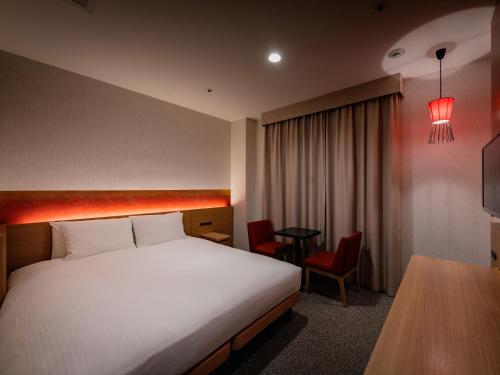 a hotel room with a bed and a table at Loisir Hotel Classic Garden Kyoto Sanjo in Kyoto