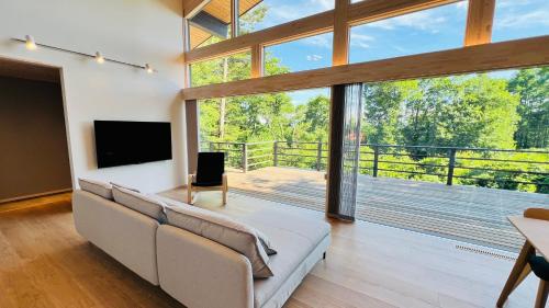 a living room with a couch and a large window at Terrace Villa Foresta Asama in Miyota