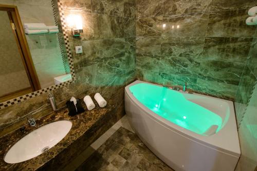 a bathroom with a tub and a sink at Georgi Hotell in Võru
