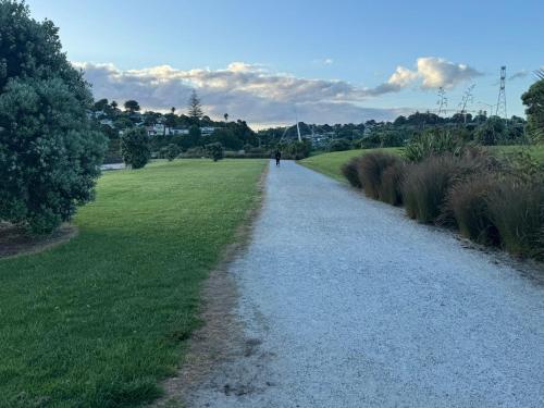 a gravel path in a field with a person walking down it at Auckland City cozy Stay in Auckland