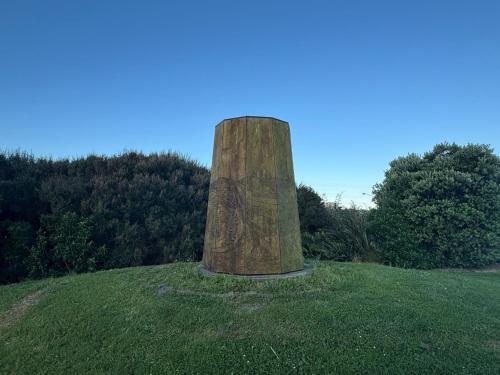 a stone pillar sitting on top of a grass field at Auckland City cozy Stay in Auckland