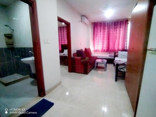 a bathroom with a sink and a living room at Farah Plaza Hostel &Hotel Apartments in Aqaba