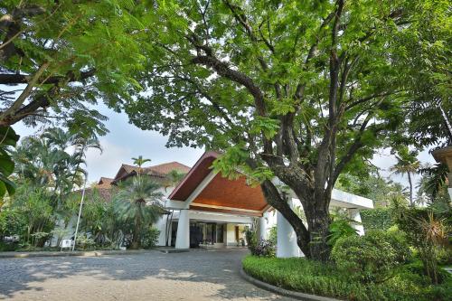 a house with a tree in front of it at The Fern-An Ecotel Hotel, Kochi in Cochin
