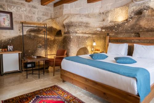 a bedroom with a large bed in a stone wall at Peruna Cave in Goreme