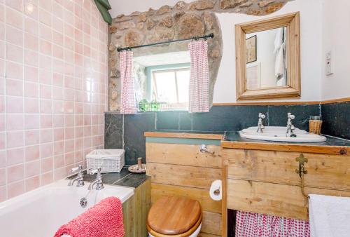 a bathroom with a bath tub and a sink at Whitebreakers, Cottage, Garden, Sea-views, Amazing Location By Beach in Sennen